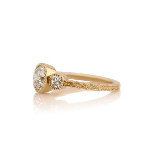 Side profile of the Penelope three stone ring showing the cushion cut side stones