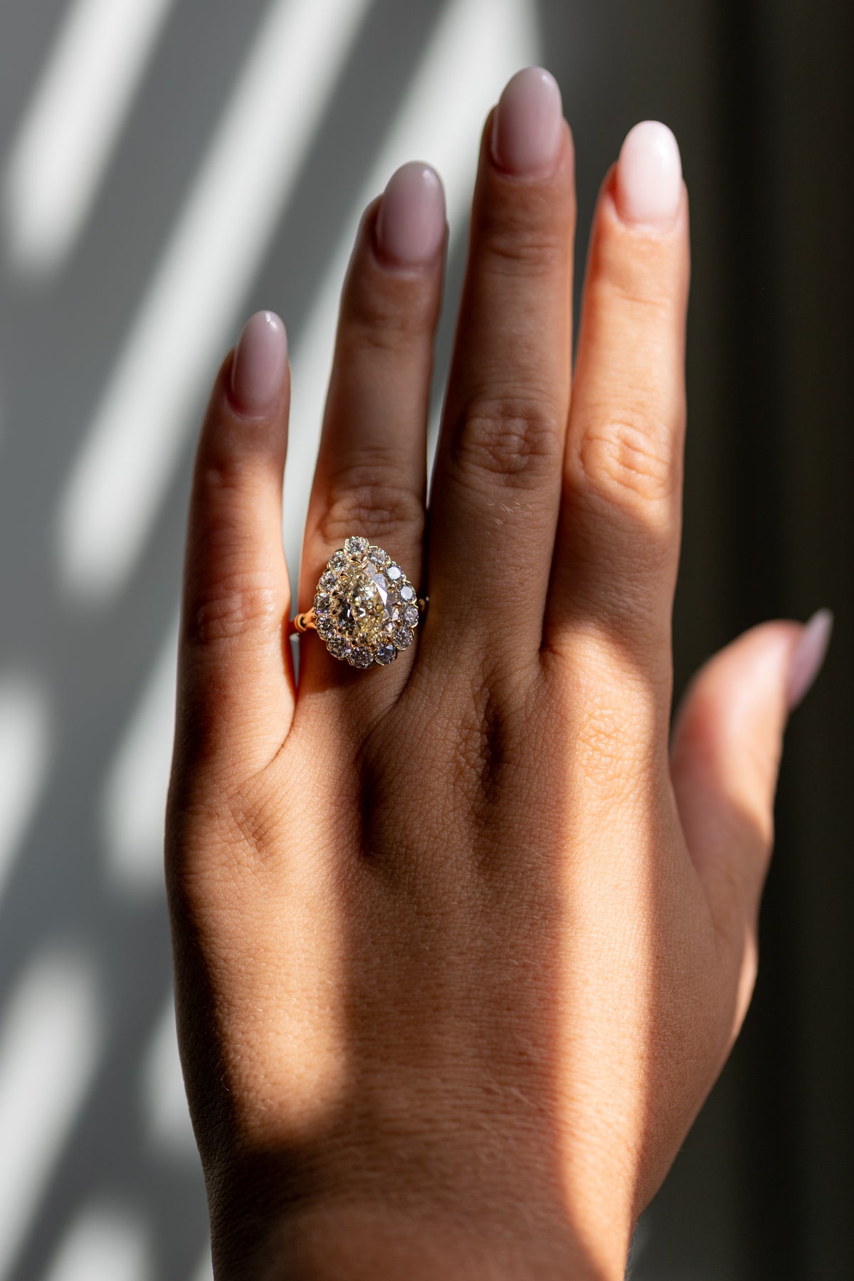 Callie 3.01ct antique cut pear halo ring worn on the hand in 14k yellow gold