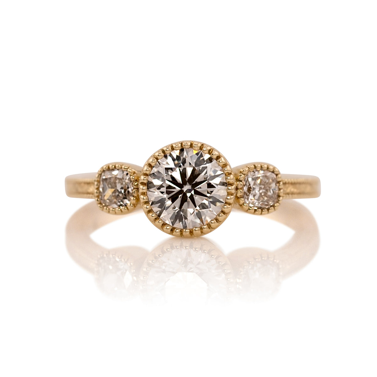 1.08ct round brilliant lab diamond three stone ring in 14k yellow gold, shown head on against a white background