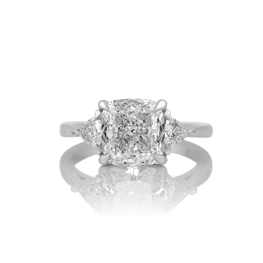 3.32ct cushion cut lab diamond three stone ring in 14k white gold, shown head on against a white background