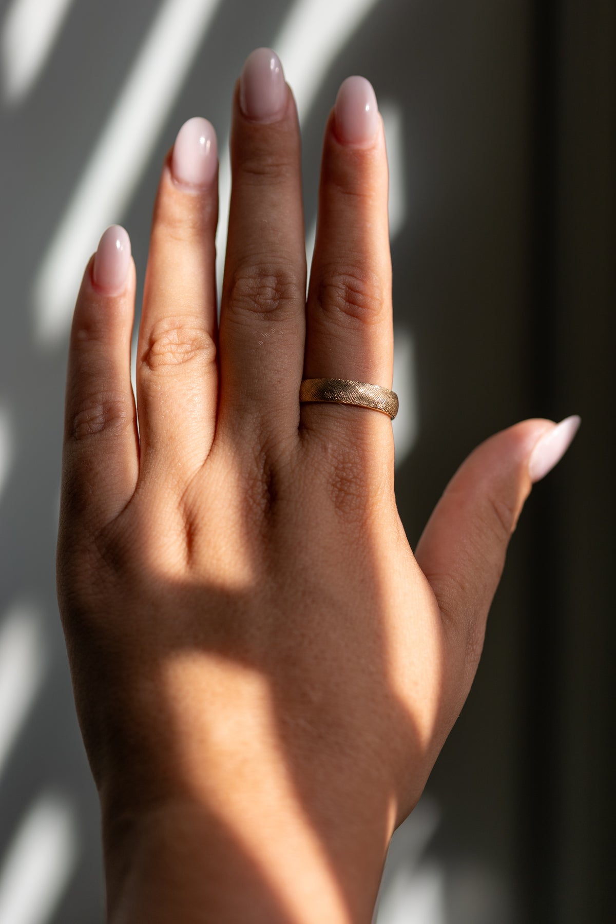 5mm Florentine texture wedding band worn on the hand in 14k yellow gold