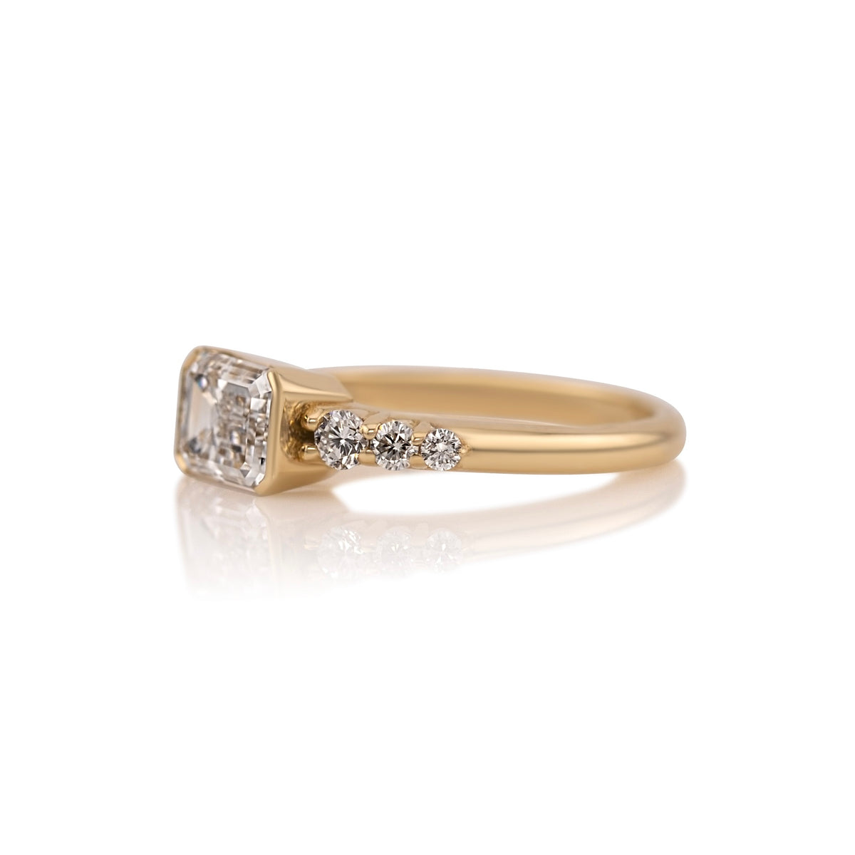 Side profile of the east west emerald cut ring showing the half bezel setting