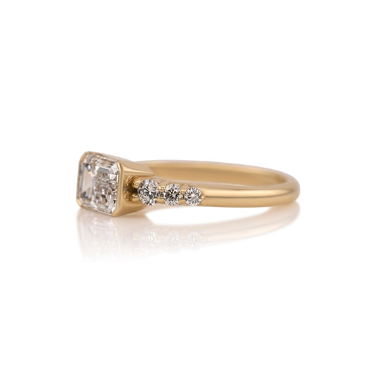 Side profile of the east west emerald cut ring showing the half bezel setting