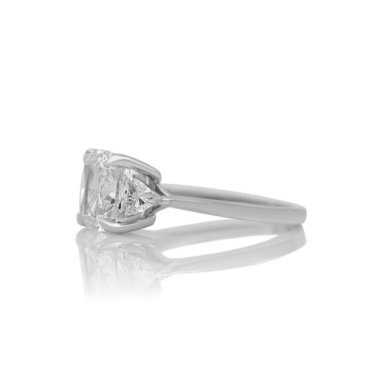 Side profile of the cushion three stone ring showing the trillion side stones
