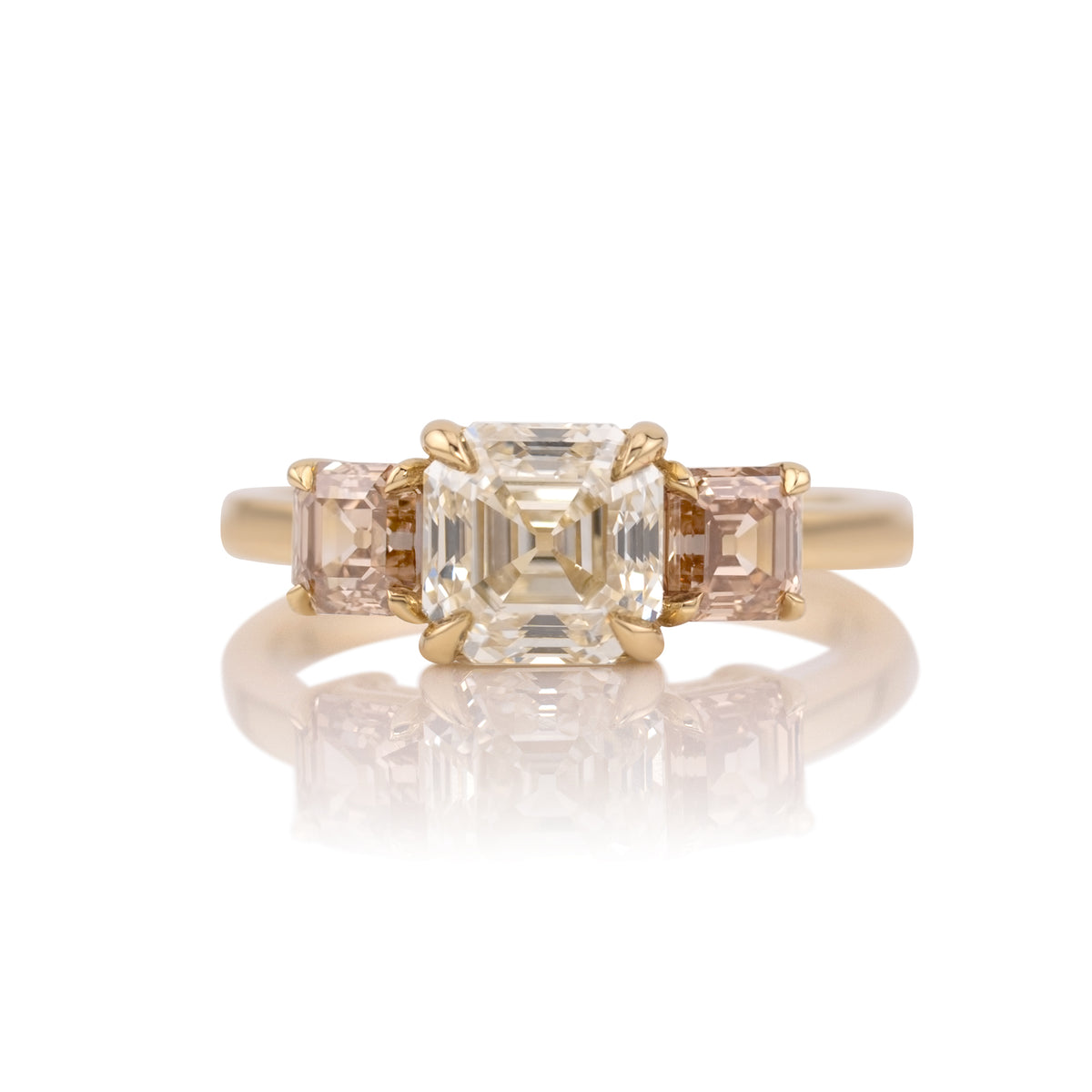 2.05ct antique Asscher cut lab diamond three stone ring in 14k yellow gold, shown head on against a white background