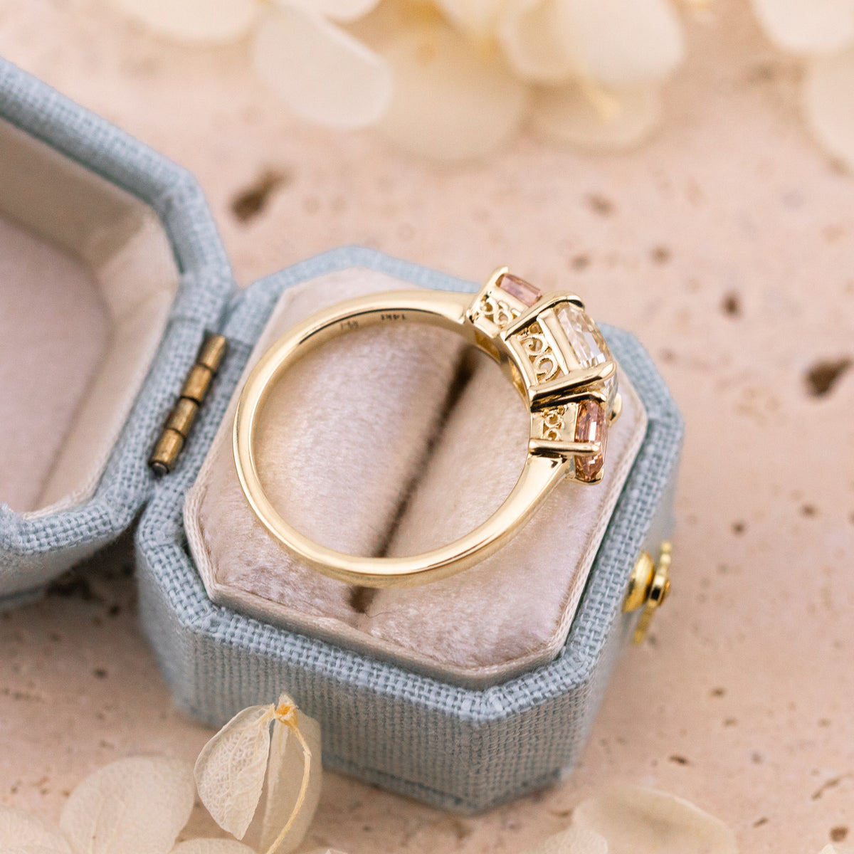 Warm K color center stone contrasting with the rosy champagne side diamonds