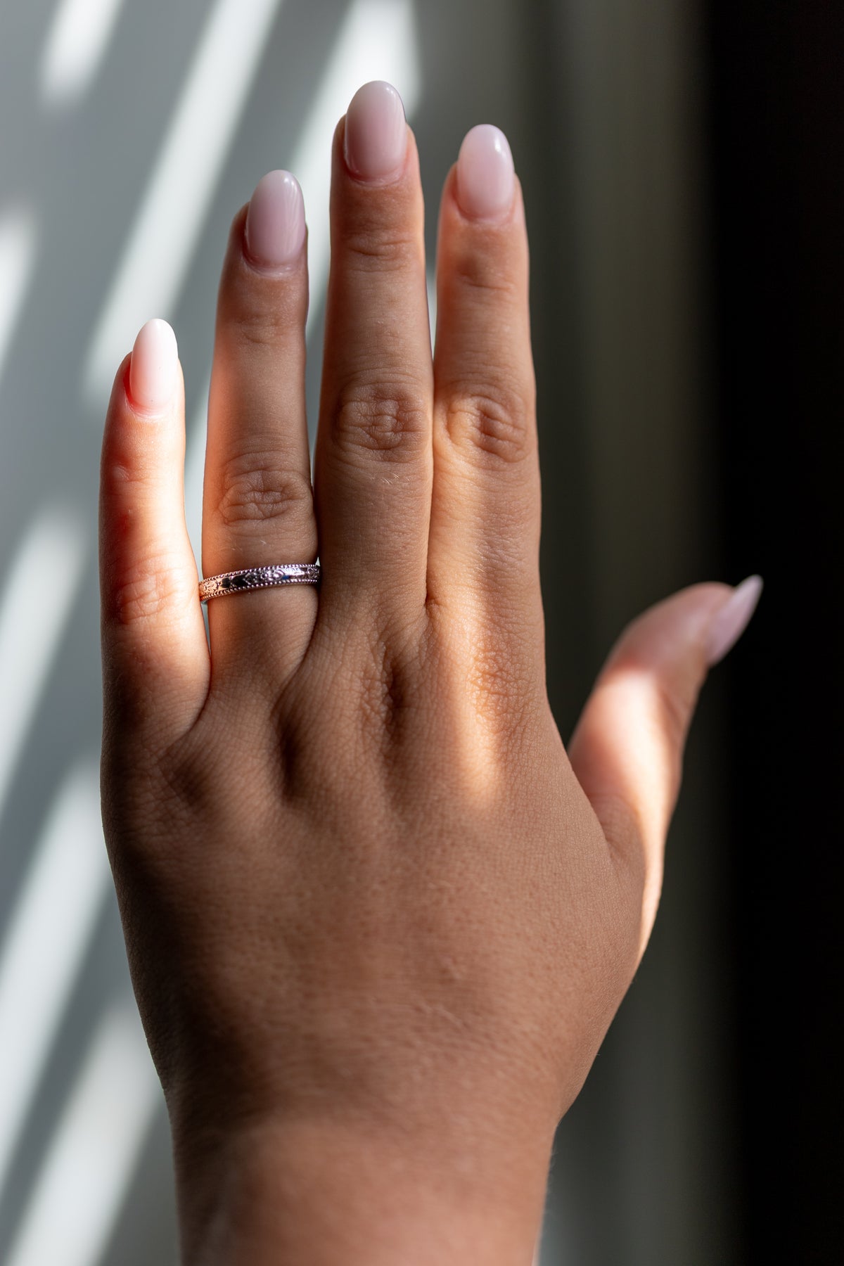 Orange blossom hand engraved wedding band worn on the hand in 14k white gold