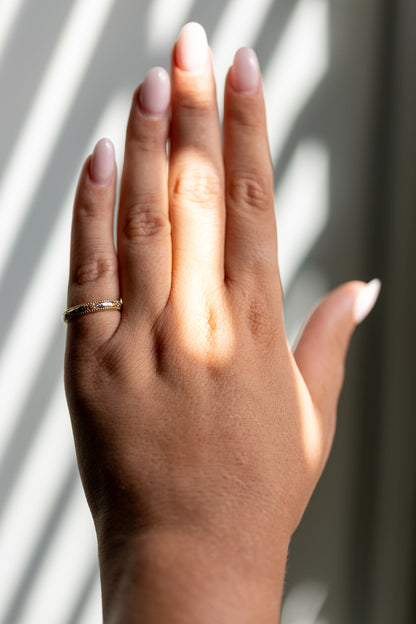 Orange blossom hand engraved wedding band worn on the hand in 14k yellow gold